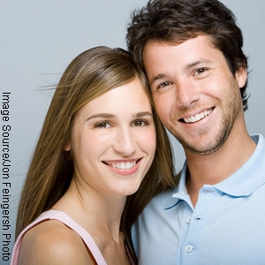 glückliches Paar nach Prophylaxe-Behandlung mit strahlend weißen Zähnen